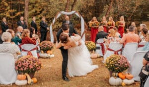 A bride and groom kissing in front of an outdoor wedding.