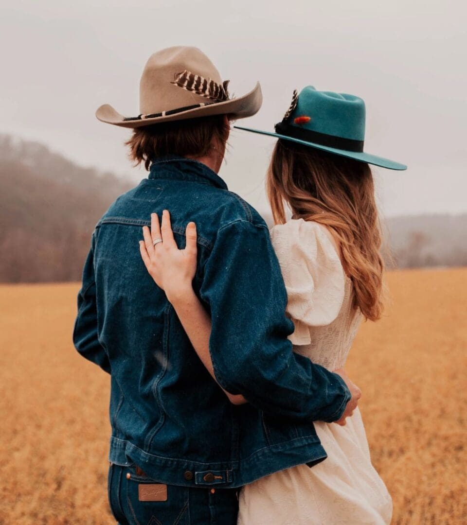 A man and woman standing in the middle of a field.