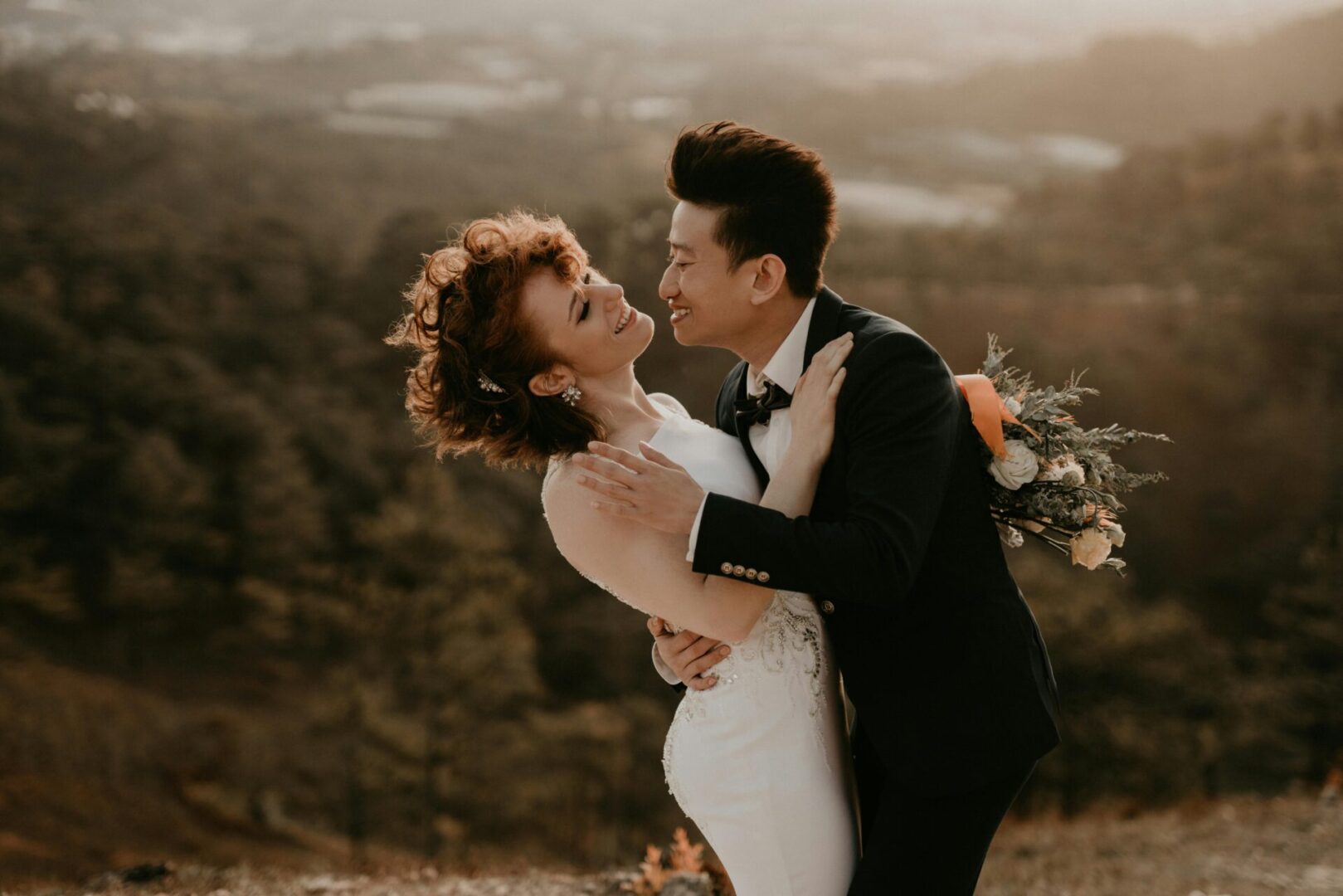 A man and woman embracing in front of the mountains.