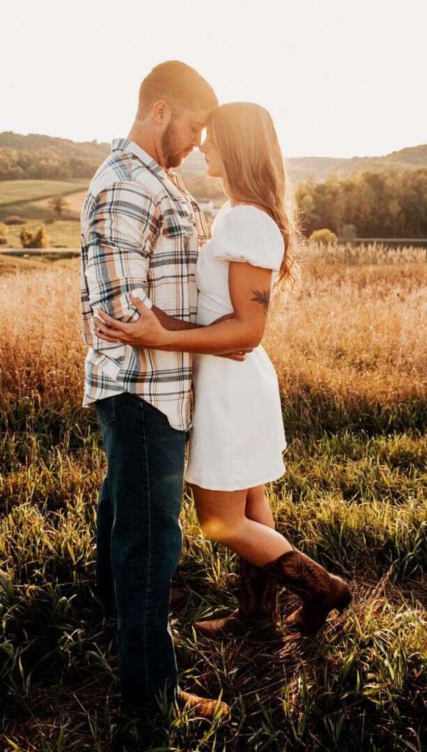 A man and woman standing in the grass.