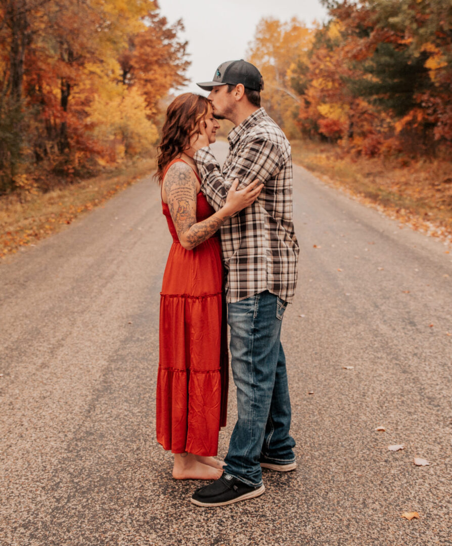 A man and woman kissing on the side of a road.