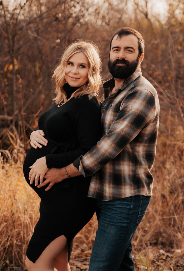 A man and woman standing in the grass.