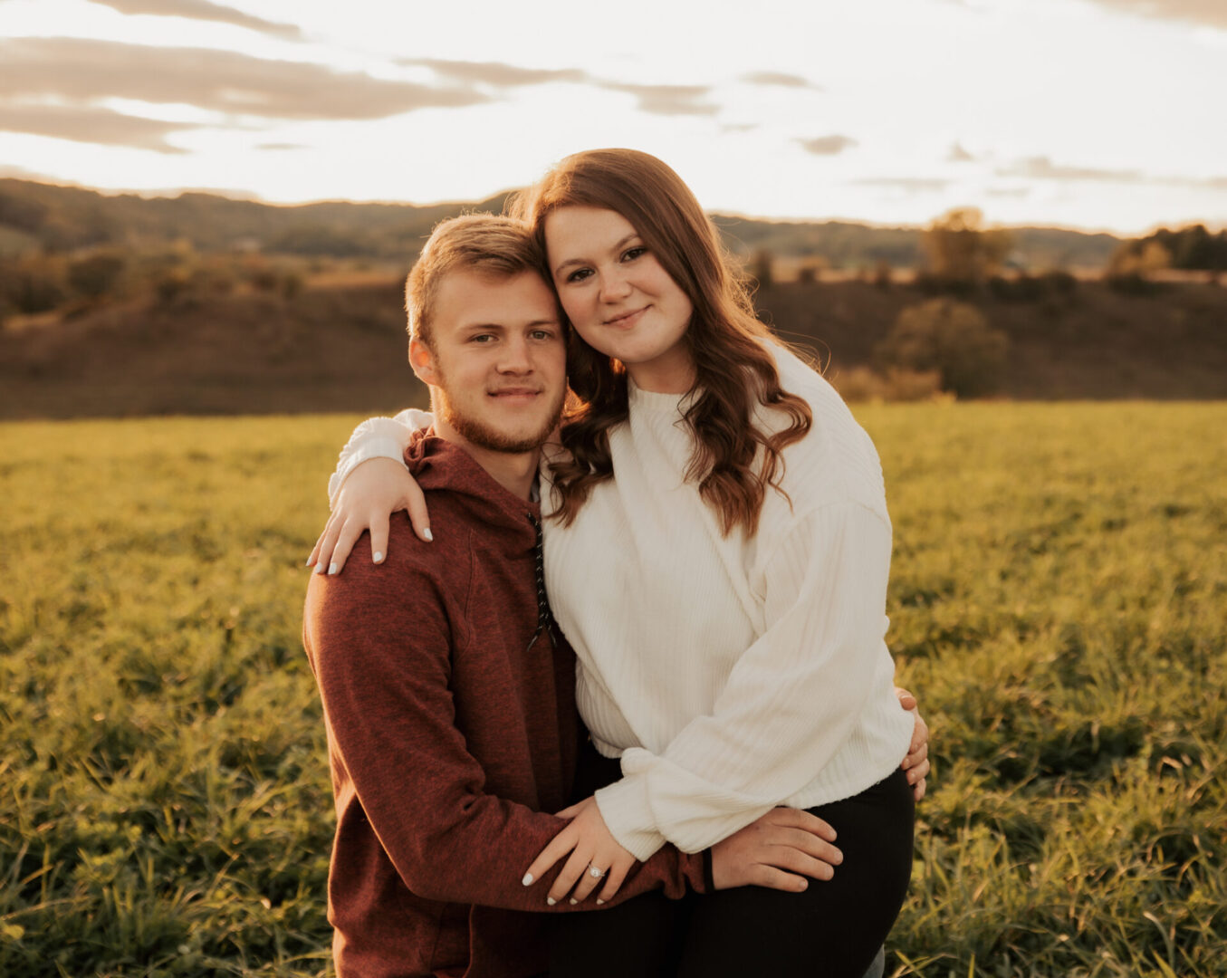 A man and woman standing in the middle of a field.