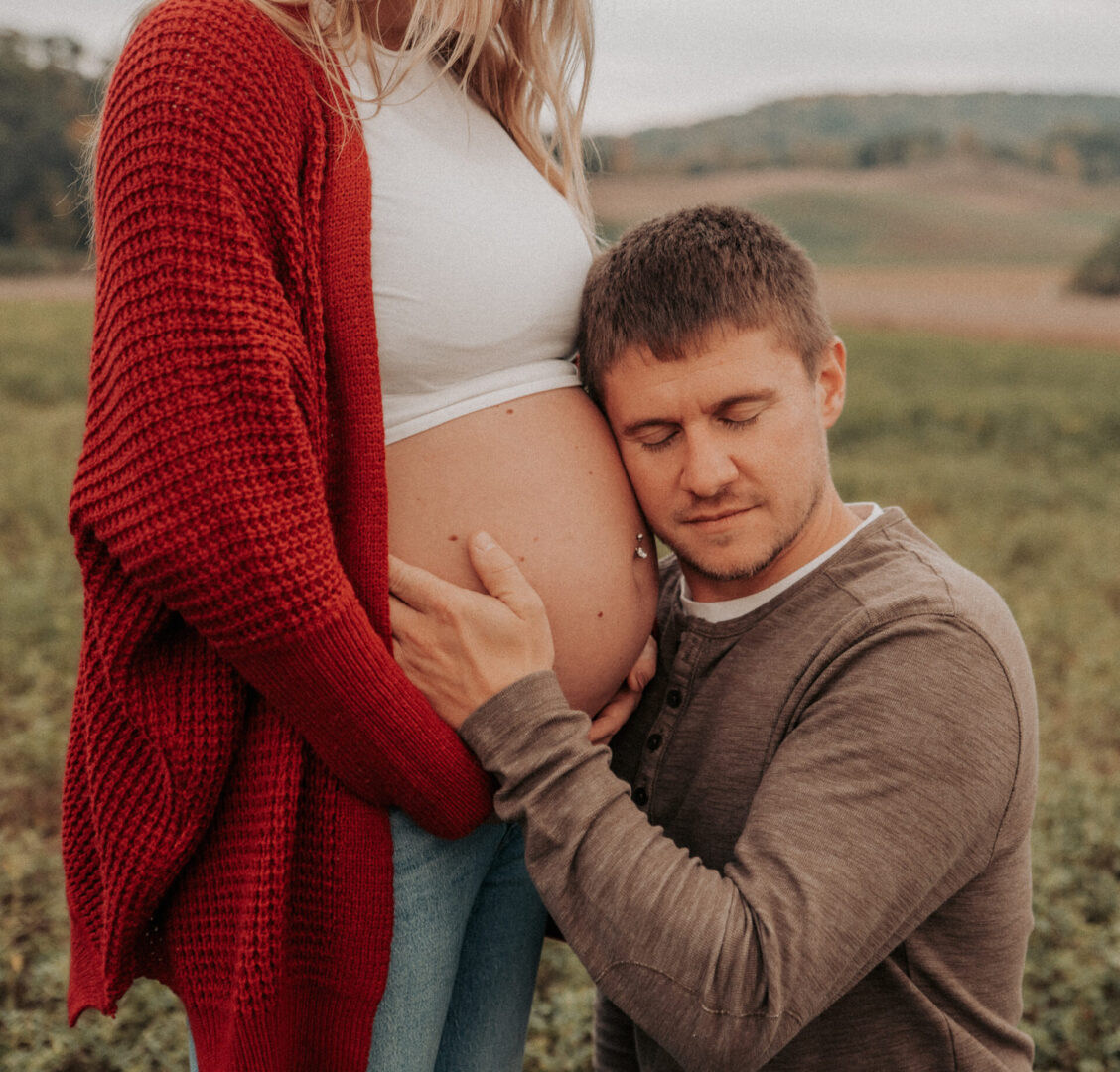 A man and woman standing in the grass.