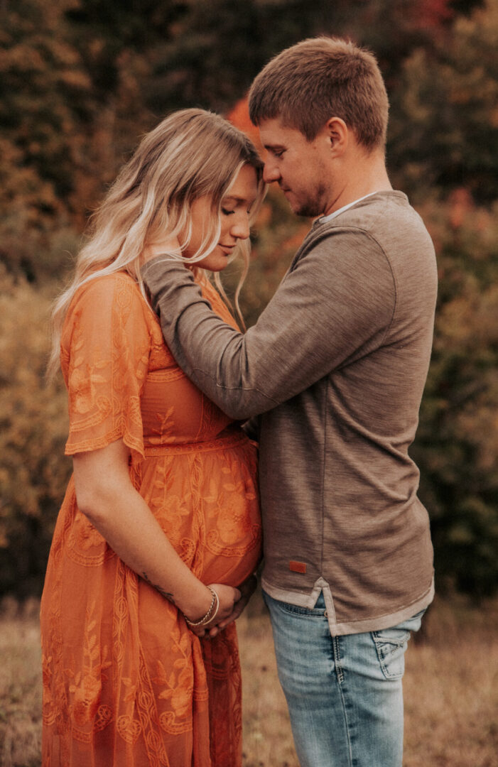 A man and woman holding hands in the grass.