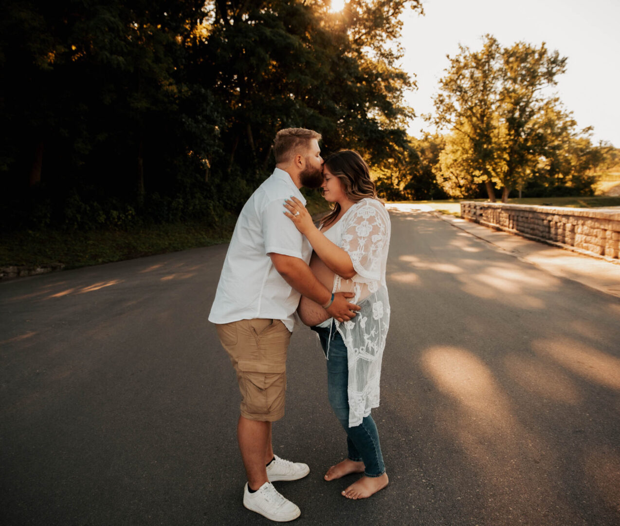 A man and woman kissing on the side of a road.