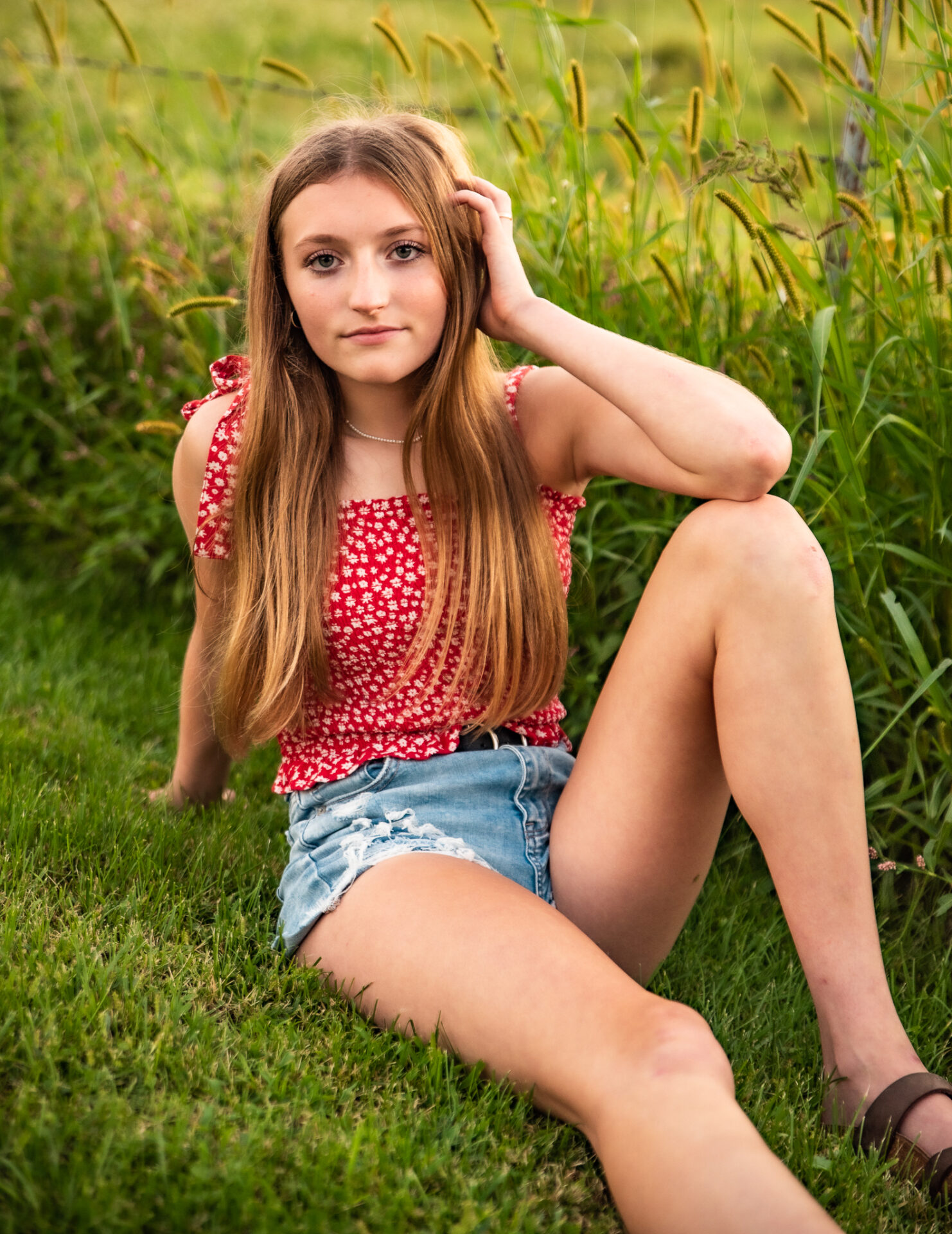 A girl sitting on the grass wearing shorts